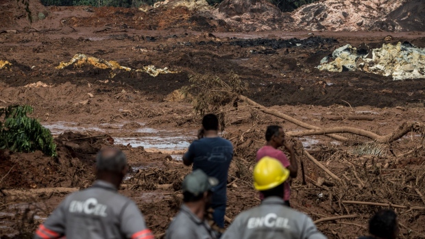 Residents survey damage after a Vale SA dam burst in Brumadinho, Minas Gerais state, Brazil, on Saturday, Jan. 26, 2019. A Brazilian judge has blocked 1 billion reais ($265 million) from Vale SA while environmental authorities imposed a $66 million fine on the miner after a tailings dam it owns burst on Friday in the second deadly accident in the same mining region in just over three years.