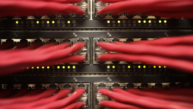Rows of colored high end data cables feeding into racks of computer servers. Photographer: Simon Dawson