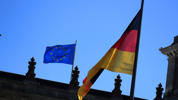 A German national flag and a European Union (EU) flag fly above the Bundestag in Berlin, Germany, on Wednesday, Sept. 9, 2020. Germany plans significant new borrowing next year to fuel the recovery of Europe’s largest economy from the fallout of the coronavirus and may continue to rely on debt spending in the future. Photographer: Krisztian Bocsi/Bloomberg