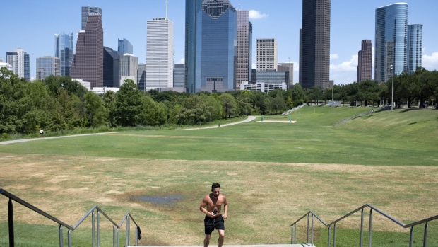 A runner jogs in Buffalo Bayou Park during a heatwave in Houston, Texas, US, on Monday, July 11, 2022. Texas residents and businesses, including the biggest names in oil, autos and technology, are being asked to conserve electricity Monday afternoon during a heatwave that's expected to push the state's grid near its breaking point.