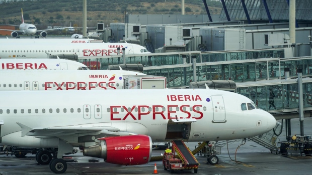 Passenger aircraft operated by Iberia Express, a unit of International Consolidated Airlines Group SA (IAG), parked at gates at Madrid Barajas airport, operated by Aena SA, in Madrid, Spain, on Thursday, Dec. 24, 2020. The coronavirus pandemic left fleets of planes grounded and caused air passenger traffic to slump as much as 94%. Photographer: Paul Hanna/Bloomberg