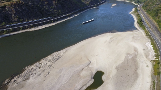 A barge travels past an exposed riverbed on the River Rhine near Oberwesel, Germany, on Friday, Aug. 12, 2022. The Rhine River fell to a new low on Friday, further restricting the supply of vital commodities to parts of inland Europe as the continent battles with its worst energy crisis in decades. Photographer: Alex Kraus/Bloomberg