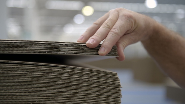 A person inspects sheets of corrugated cardboard. Photographer: Carla Gottgens/Bloomberg