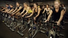 People exercise during a class at a SoulCycle fitness studio. SoulCycle, bought by Equinox in 2011, now has nine locations in New York.