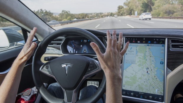 A member of the media test drives a Tesla Motors Inc. Model S car equipped with Autopilot in Palo Alto, California, U.S., on Wednesday, Oct. 14, 2015. Tesla Motors Inc. will begin rolling out the first version of its highly anticipated "autopilot" features to owners of its all-electric Model S sedan Thursday. Autopilot is a step toward the vision of autonomous or self-driving cars, and includes features like automatic lane changing and the ability of the Model S to parallel park for you. Photographer: David Paul Morris