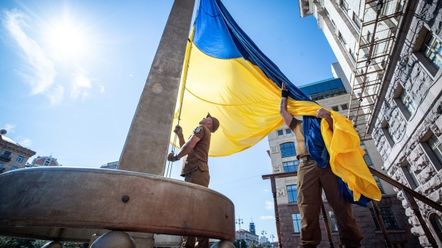 Ukrainian military members raise a flag on the Day of Ukrainian Statehood near City Hall in Kyiv on July 28.
