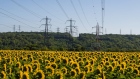 Electricity power lines above a field of sunflowers near the decomissioned Porcheville fuel power plant, operated by Electricite de France SA (EDF), in Porcheville, France, on Friday, July 8, 2022. The French government will nationalize its financially struggling nuclear giant Electricite de France SA to help it ride out Europe’s worst energy crisis in a generation and invest in new atomic plants. Photographer: Nathan Laine/Bloomberg