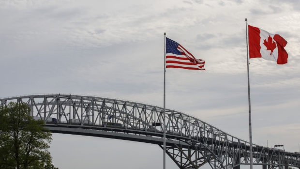 Canadian and U.S. flags fly at the base of the Bluewater Bridge, which connects Canada and the U.S., near the Enbridge Line 5 pipeline in Sarnia, Ontario, Canada, on Tuesday, May 25, 2021. Enbridge Inc. said it will continue to ship crude through its Line 5 pipeline that crosses the Great Lakes, despite Michigan Governor Gretchen Whitmer's order to shut the conduit.