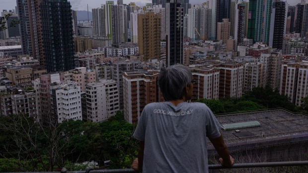 A hiker on a hill looks at residential buildings in Hong Kong, China, on Saturday, June 11, 2022. Hong Kong is preparing to cocoon some 1,000 people involved in the city’s July 1 handover anniversary, fueling speculation that Chinese President Xi Jinping will attend the celebrations.