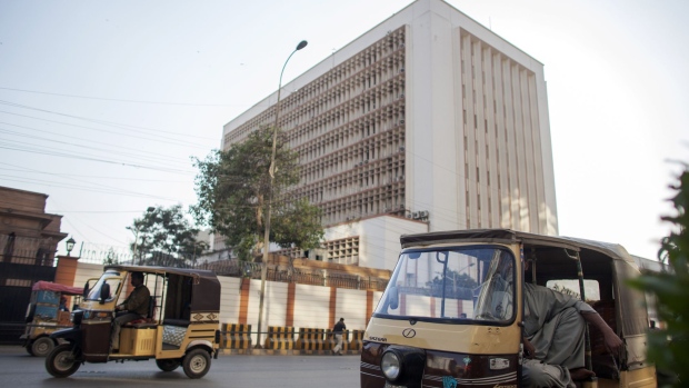 Auto rickshaws travel past the State Bank of Pakistan building in Karachi, Pakistan, on Thursday, Dec. 14, 2017. Pakistan's rupee weakened to a record low after the central bank continued to ease its grip on the currency amid mounting economic pressure and speculation that the country may need International Monetary Fund support. Photographer: Asim Hafeez/Bloomberg