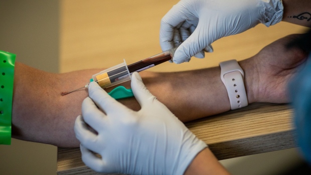 A paramedic, right, takes a blood sample from a front line ambulance worker during an antibody testing program at the Hollymore Ambulance Hub of the West Midlands Ambulance Service, operated by the West Midlands Ambulance Service NHS Foundation Trust, in Birmingham, U.K., on Friday, June 5, 2020. Making antibody tests widely available may help Britain lift its lockdown restrictions, because they show who has already had the virus and might have a degree of immunity. Photographer: Simon Dawson/Bloomberg