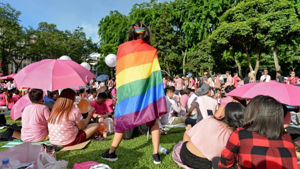 A supporter wrapped in a rainbow flag attends the annual "Pink Dot" event in a public show of support for the LGBT community at Hong Lim Park in Singapore. Photographer: Roslan Rahman/AFP/Getty Images