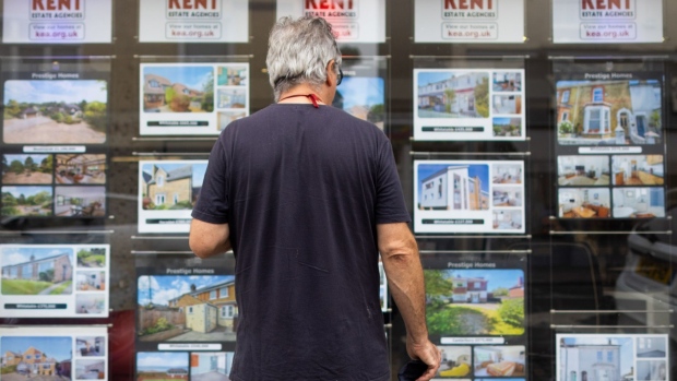 A pedestrian looks at houses for sale in the window of an estate agents in Whitstable, UK, on Tuesday, Aug 16, 2022. Inflation, which is at a 40-year high and set to accelerate, meant the volume of goods purchased declined even as the value of spending increased, the British Retail Consortium said. Photographer: Chris Ratcliffe/Bloomberg