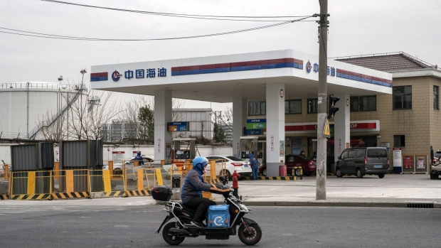 A motorist travels past a Cnooc Ltd. gas station in Shanghai, China, on Thursday, Jan. 7, 2021. China's energy markets are tightening as the economy rebounds and freezing weather grips much of the northern hemisphere, a dynamic that’s likely to be exacerbated by reduced Saudi oil output. Photographer: Qilai Shen/Bloomberg