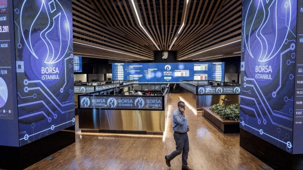 A visitor crosses the trading floor while using a mobile phone at the Borsa Istanbul SA stock exchange in Istanbul, Turkey, on Tuesday, Aug. 14, 2018. While they are growing more critical, the underlying tone of warnings from businesses has so far been supportive of the government in principle, showing there are limits to how much Turkey’s billionaires are feeling emboldened to speak out after elections in June increased President Recep Tayyip Erdogan’s grip on power.