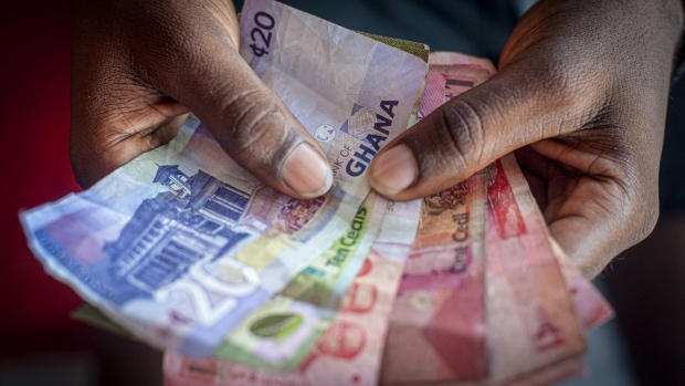 A vendor counts Ghana cedi banknotes at a market in Accra, Ghana, on Tuesday, Oct. 23, 2020. Ghana is missing out on a rally of African bonds as investors fret about an expansion in spending and borrowing ahead of elections in December. Photographer: Cristina Aldehuela/Bloomberg