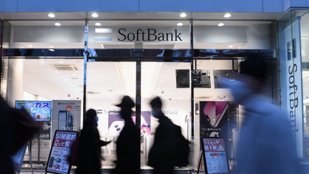 Pedestrians walk past a SoftBank Corp. store in Tokyo, Japan, on Sunday, Jan. 30, 2022. SoftBank Corp., a subsidiary of investment firm SoftBank Group Corp., is scheduled to release it's third-quarter earnings figures on February 3.