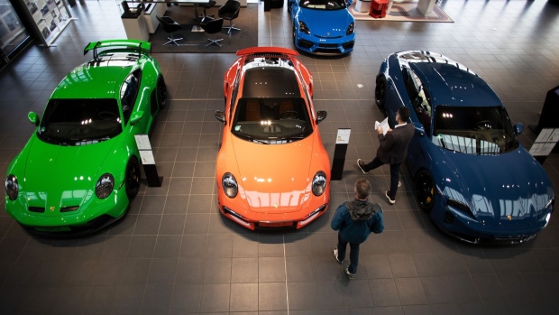 A customer looks at a Porsche GT3, left, a Porsche 911 Turbo, center, and a Porsche Taycan Turbo S automobile at a Porsche SE showroom in Berlin, Germany, on Tuesday, March 29, 2022. Porsche, which reports reports final year earnings today, delivered 301,915 vehicles to customers in 2021, an 11% jump from 2020 and the first time it has surpassed the 300,000 mark.