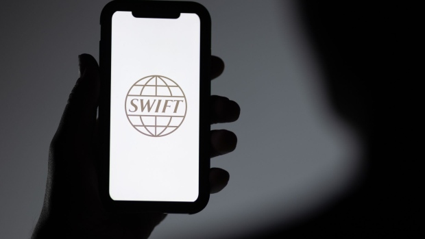 The Society for Worldwide Interbank Financial Telecommunication (SWIFT) company logo displayed on a smartphone arranged in London, U.K. on Monday, Feb. 28, 2022. A decision to penalize Russia's central bank and exclude some Russian banks from the SWIFT messaging system, used for trillions of dollars worth of transactions around the world, was announced Saturday in a joint statement by the U.S., European Commission, France, Germany, Italy, U.K. and Canada. Photographer: Jason Alden/Bloomberg