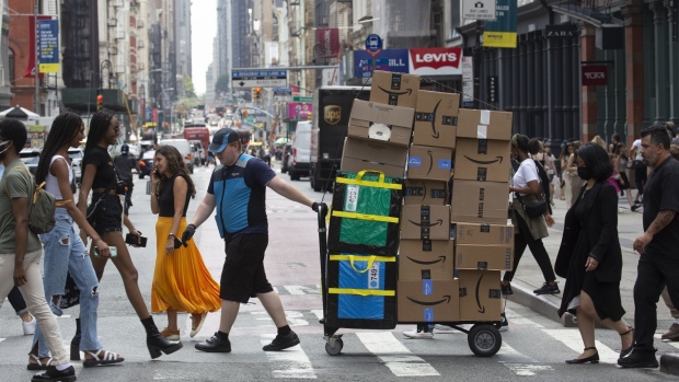 A worker delivers packages on Amazon Prime Day in New York, US, on Tuesday, July 12, 2022. Bargain hunters are expected to find Amazon.com Inc.'s two-day Prime Day sale underwhelming this year, with many sellers minimizing profit-eating discounts in an era of soaring costs.