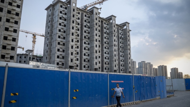 A man walks past the China Evergrande Group Royal Peak residential development under construction in Beijing, China, on Friday, July 29, 2022. A mild rally in Chinese developers’ dollar bonds appears to be losing momentum, as investors express disappointment that a top leadership meeting failed to unveil stronger policy support for the crisis-ridden industry. Bloomberg