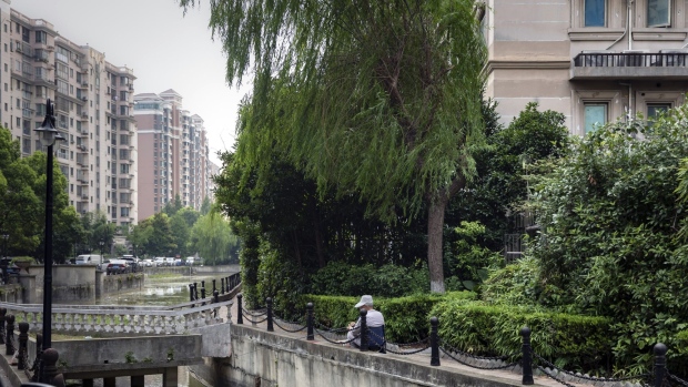 A resident sits along a canal in the Kangcheng neighborhood of Shanghai, China, on Monday, Aug. 1, 2022. In a country that only tolerates dissent in small doses—and relies on property as its economic growth engine—a mortgage boycott by hundreds of thousands of middle-class Chinese has become a five-alarm fire for authorities. Photographer: Qilai Shen/Bloomberg