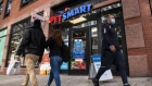 A pedestrian wearing a protective mask walks a dog outside a PetSmart store in the Brooklyn borough of New York, U.S., on Tuesday, Oct. 27, 2020. PetSmart Inc. is kicking off a $2.35 billion junk bond offering as part of a larger financing package that will separate the company from its online counterpart Chewy Inc.