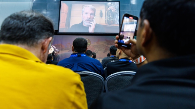 People watch a streaming interview with Michael Saylor, Chairman & CEO, MicroStrategy in the exhibition hall at the Australian Crypto Convention in the Gold Coast, Australia, on Saturday, September 17, 2022. Photographer: Ian Waldie/Bloomberg
