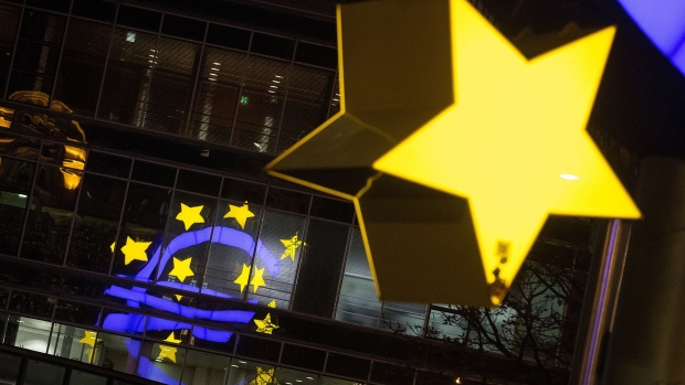 A star of the euro sign sculpture hangs illuminated near the former European Central Bank (ECB) headquarters at night in Frankfurt, Germany, on Monday, Nov. 6, 2017. Demand for offices in Frankfurt and prime rents have climbed to a record as the city emerges as one of the favorites to attract financial firms from London in the run-up to the U.K.’s exit from the European Union, according to lobby group Frankfurt Main Finance. Photographer: Krisztian Bocsi/Bloomberg