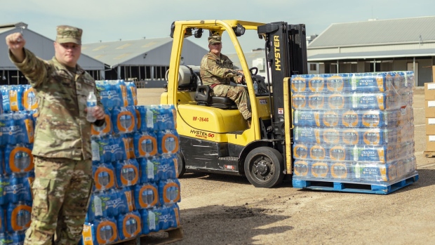 Members of the National Guard distribute water during a water shortage in Jackson, Mississippi, US, on Friday, Sept. 2, 2022. The governor of Mississippi called in the National Guard to help residents of the state capital after a plant failure left at least 180,000 people in the area without access to safe water.