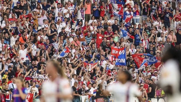 Fans of Olympique Lyonnais cheer during a match in Turin, Italy.