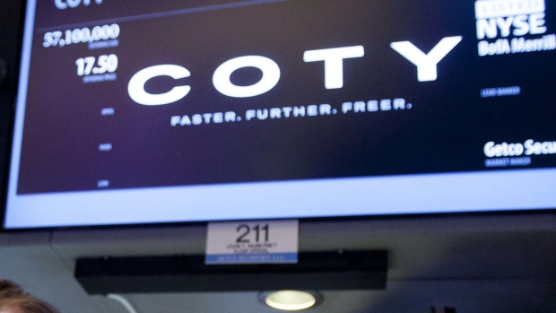 Traders work at the Coty Inc. booth on the floor of the New York Stock Exchange (NYSE) in New York, U.S., on Thursday, June 13, 2013. Coty Inc., maker of perfumes endorsed by Beyonce and Heidi Klum, was little changed in New York trading after raising about $1 billion on behalf of existing holders in an initial public offering yesterday.