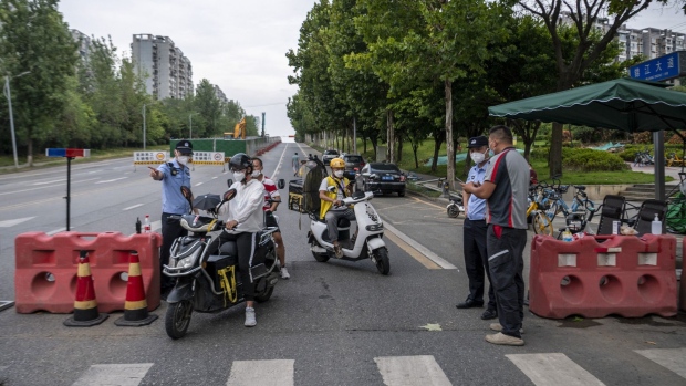 This photo taken on September 1, 2022 shows police officers checking information on a road amid restrictions due to an outbreak of the Covid-19 coronavirus in Chengdu, in China's southwestern Sichuan province.  Photographer: -CNS/AFP/Getty Images