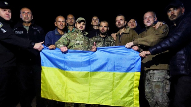 Returned servicemen hold a Ukrainian national flag following a prisoner swap, in Cherhnihiv region in the north of Ukraine. Security Service of Ukraine Source: Security Service of Ukraine/Anadolu Agency/Getty Images