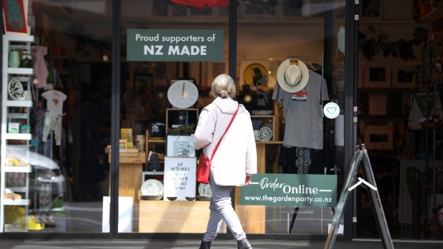 A pedestrian passes a store in Auckland, New Zealand, on Tuesday, Sept. 13, 2022. New Zealand is scheduled gross domestic product (GDP) figures on Sept. 15. Photographer: Fiona Goodall/Bloomberg