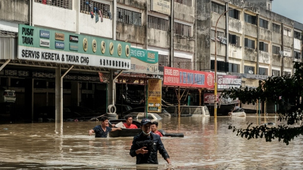 Residents wade through floodwaters in the Taman Sri Muda township of Shah Alam, Selangor, Malaysia, on Monday, Dec. 20, 2021. Floods hit the Southeast Asian nation annually during the monsoon season, but those at the weekend were the worst in years.