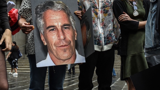 A protest group holds up signs of Jeffrey Epstein in front of the Federal courthouse in New York on July 8, 2019. Photographer: Stephanie Keith/Getty Images