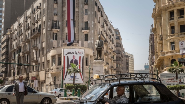 Traffic moves around a building adorned with an election banner in support of Abdel-Fattah El-Sisi, Egypt's president, in Cairo, Egypt on March 31, 2018. El-Sisi was set to sweep to victory with more than 90 percent of the vote in this week's election, crushing his one token challenger after credible competitors were eliminated before the contest.
