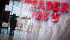 Shoppers are reflected in a window in front of Trader Joe's grocery store signage at City Point in the Brooklyn borough of New York, U.S., on Tuesday, July 18, 2017. Bloomberg is scheduled to release consumer comfort figures on July 20.
