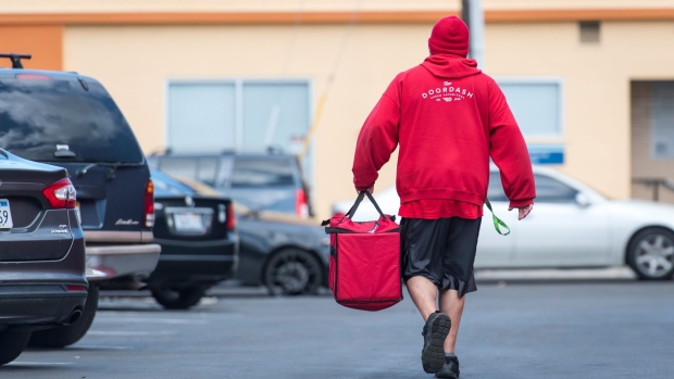 A DoorDash Inc. delivery person carries an order bag outside of a DoorDash Kitchens location in Redwood City, California, U.S., on Friday, Nov. 29, 2019. Doordash, an on-demand food delivery service, unveiled their first shared commissary kitchen concept that can house up to five restaurants, offering a cost-saving alternative to traditional brick and mortar locations. Photographer: David Paul Morris/Bloomberg