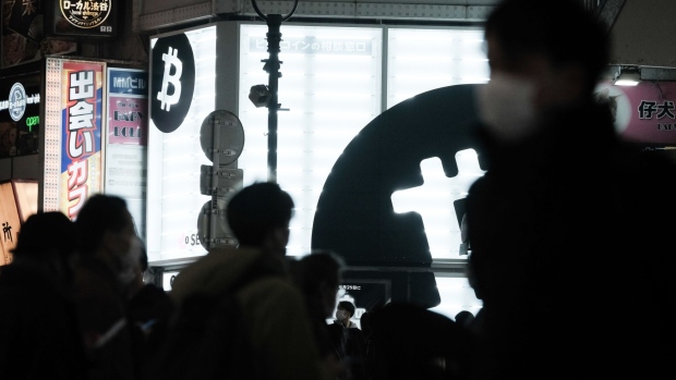 Pedestrians outside a Sakura Bitcoin Exchange Inc. store in the Shibuya district of Tokyo on Friday, Feb. 25, 2022. Cryptocurrency exchanges are still trying to figure out how to deal with western sanctions against Russia after its invasion of Ukraine. Photographer: Soichiro Koriyama/Bloomberg