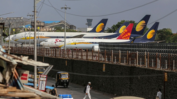 Jet Airways India Ltd. and a SpiceJet Ltd. aircraft at Chhatrapati Shivaji Maharaj International Airport in Mumbai, India, on Wednesday, May 26, 2021. India is preparing a stimulus package for sectors worst affected by a deadly coronavirus wave, aiming to support an economy struggling with a slew of localized lockdowns, people familiar with the matter said. The finance ministry is working on proposals to bolster the tourism, aviation and hospitality industries, along with small and medium-sized companies. Photographer: Dhiraj Singh/Bloomberg