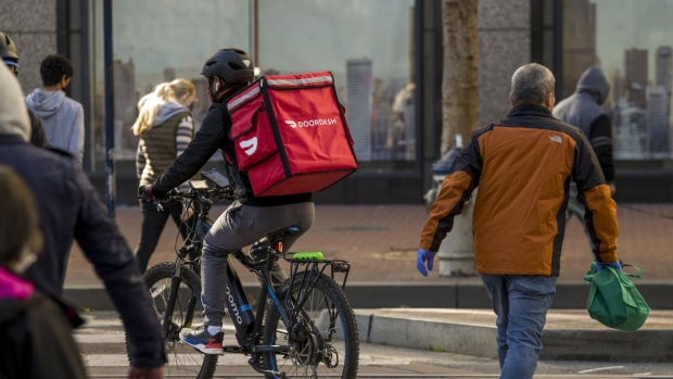 A bike messenger carries a DoorDash Inc. bag in San Francisco, California, U.S., on Wednesday, Dec. 23, 2020. Bloomberg is scheduled to release consumer comfort figures on December 24.