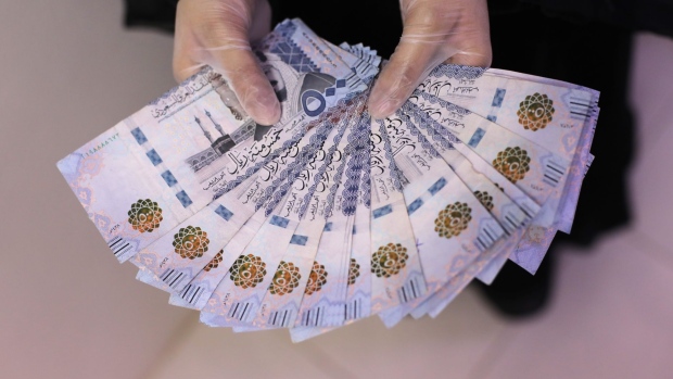 A woman displays 500 denomination Saudi Arabian riyal (SAR) banknotes, in this arranged photograph in Riyadh, Saudi Arabia, on Wednesday, July 29, 2020. Facing a twin crisis from the coronavirus pandemic and oil market turmoil, the government has taken unprecedented measures to steady its finances, including tripling value-added tax, increasing import fees, and canceling some benefits for government workers. Photographer: Maya Anwar/Bloomberg