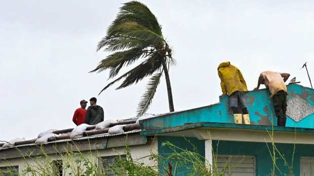 Cubans repair a roof in San Juan y Martinez, Pinar del Rio Province, on September 27, 2022 after the passage of Hurricane Ian.  Photographer: Adalberto Roque/AFP/Getty Images