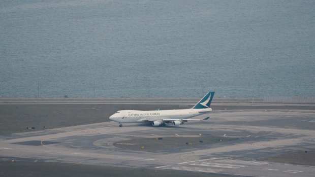A cargo aircraft operated by Cathay Pacific Airways Ltd. on the tarmac at the Hong Kong International Airport in Hong Kong, China, on Monday, March 7, 2022. A total of 5,082 people departed Hong Kong on Sunday, the most since the city was hit with its most severe and far-reaching wave of Covid. That took last week's tally to a net 22,965 departures from all ports.
