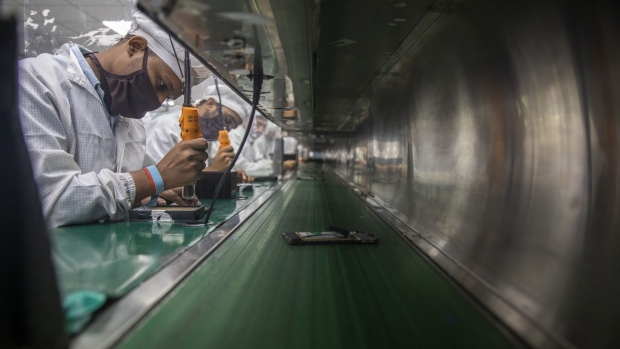 Workers manufacture smart phones on an assembly line at the Lava International Ltd. factory in Noida, Uttar Pradesh, India, on Tuesday, Sept. 22, 2020. Under the Production Linked Incentive program, or PLI as it’s called, manufacturing incentives will rise each year in an ongoing effort to entice the world’s biggest smartphone brands to make their products in India and export to the world. Photographer: Prashanth Vishwanathan/Bloomberg