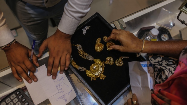 A customer inspects gold jewelry inside the Umedmal Tilokchand (U.T) Zaveri jewellery store during the festival of Dhanteras at the Zaveri Bazaar in Mumbai, India, on Friday, Nov. 13, 2020. India’s main holiday season -- culminating Saturday with Diwali, the festival of lights -- appears to be giving a much needed boost to demand, with online retail sales to business activity indicators signaling Asia’s third-largest economy is recovering.