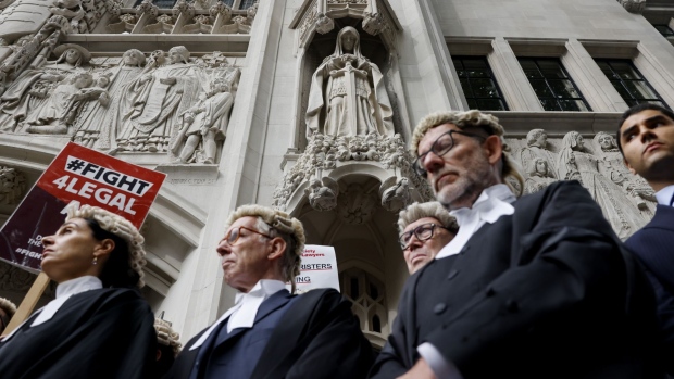 Criminal lawyers protest during their indefinite strike near an ornamental statues at the Supreme Court in central London, UK, on Tuesday, Sept. 6, 2022. Most of the UK's criminal trial lawyers started an indefinite strike on Monday, escalating a protest with the government over funding and fees and bringing the country’s crumbling justice system to a standstill.