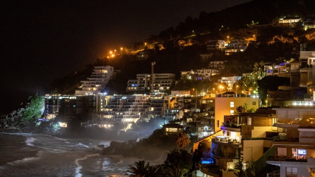 Lights illuminate residential seafront properties in the Clifton district of Cape Town, South Africa, on Tuesday, Aug. 2, 2022. South Africa's state-owned power utility Eskom Holdings SOC Ltd. warned it may have to implement rolling blackouts for the first time in more than a week due to a shortage of generation capacity.